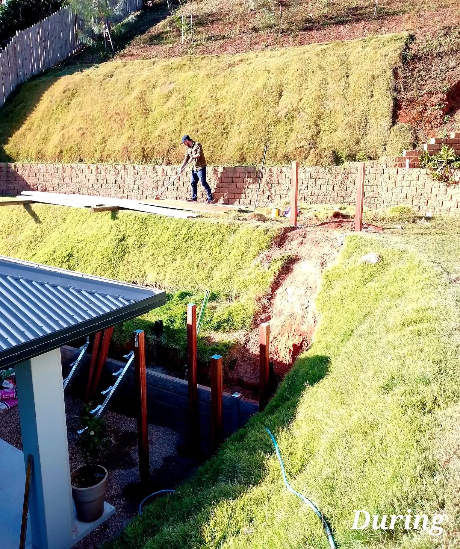 Block retaining wall under construction on a steep residential slope