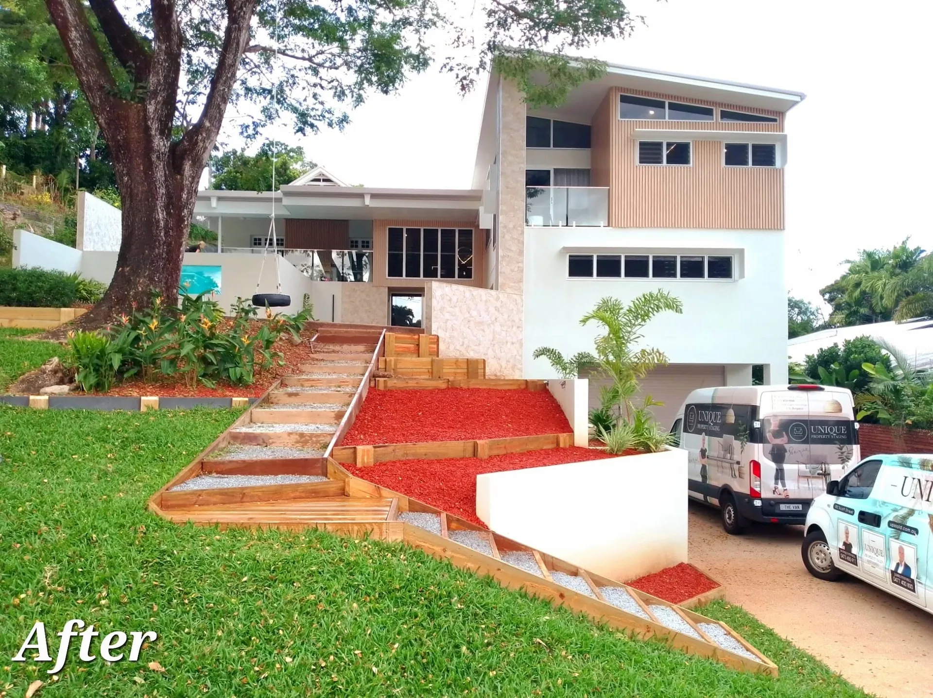 Timber landscape stairs and tiered garden beds built into the slope at a modern home