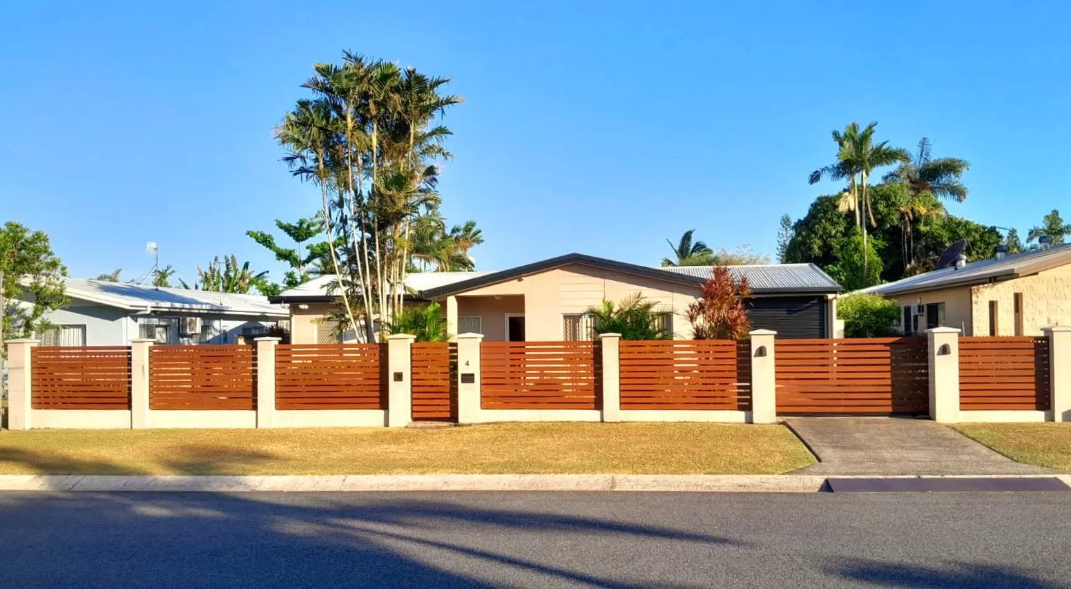 Horizontal timber slat fence with rendered pillars along a street frontage
