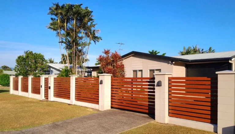 Horizontal timber slat fence and matching gate on rendered pillars