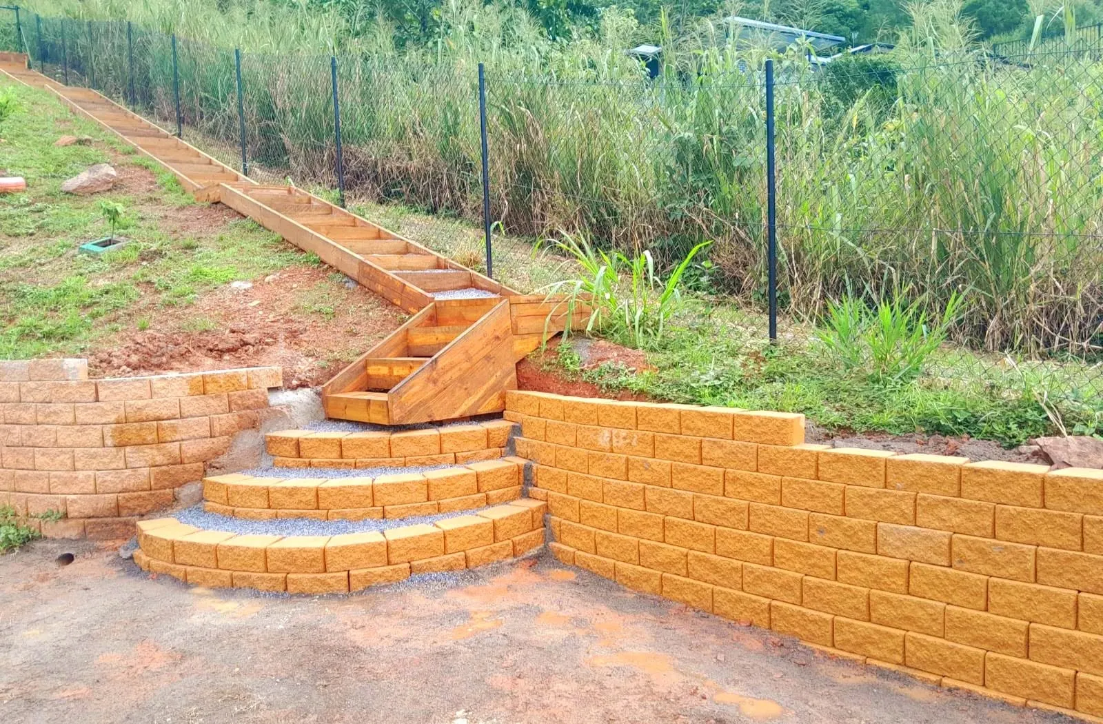 Sandstone block retaining wall with curved steps built into a sloping garden