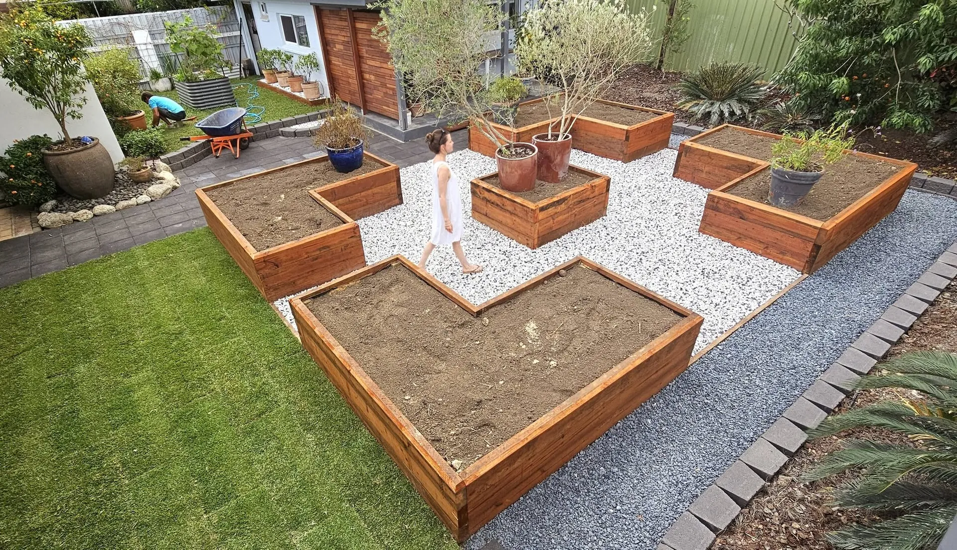 Raised timber garden beds with gravel paths and lawn in a landscaped Hervey Bay backyard