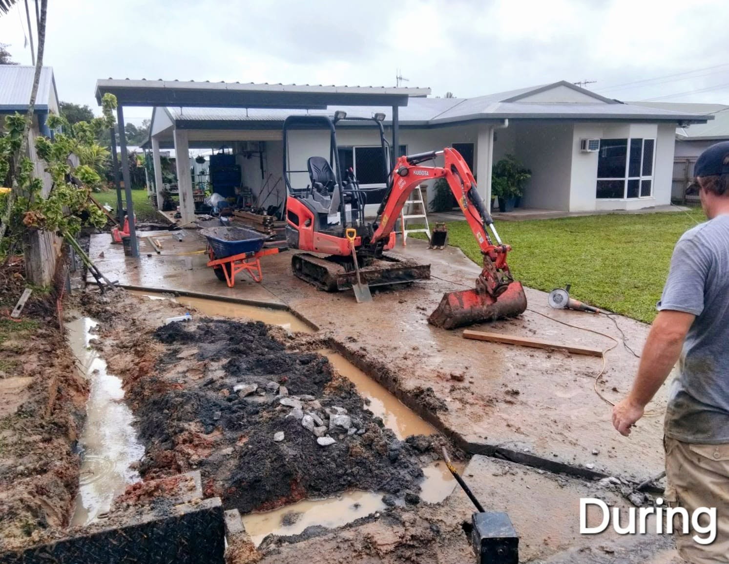 Excavator trenching for drainage during groundworks at a residential property